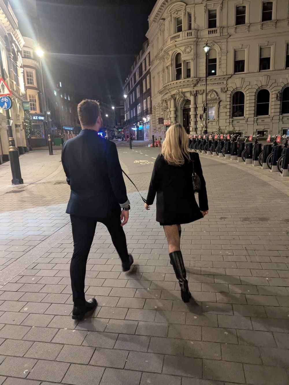 The candidate walking through central London at night, on a leash held by a fellow guest.